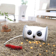 Owl Pet Robot – Interactive Toy with Camera & Treat Dispenser on carpet, surrounded by treats and a feather toy for pet engagement.